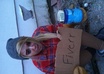 hold a cardboard sign with your message on it, dressed as a hobo